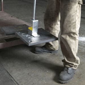 Person using magnetic lifter on metal sheet.