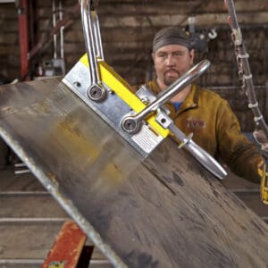 Man operating industrial lifting equipment indoors.