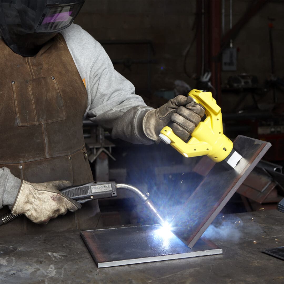 Welder working with protective gear and torch.